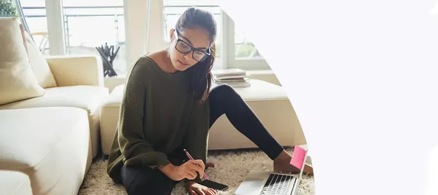 woman sitting on the floor in front of couch on her laptop